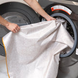 A person loading a Bumkins Splat Mat: Wander into an open front-loading washing machine.