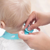 Close-up of hands fastening the closure of a Bumkins Silicone Bib: Ocean Life around a child's neck.