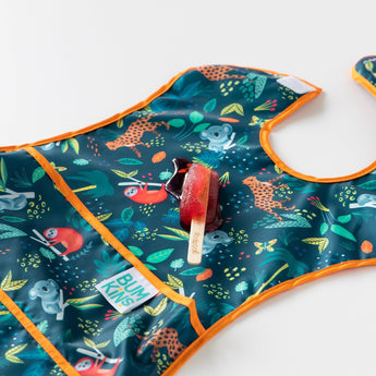 A red popsicle melts on top of Bumkins Super-Sized SuperBib®: Jungle on a white background.