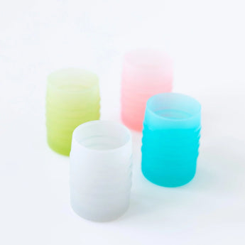 Four cups, including Bumkins Silicone Starter Cup: Gray, sit on a white background.