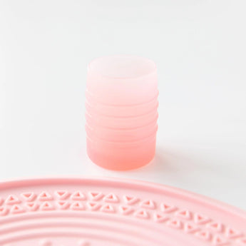 Bumkins Silicone Starter Cup: Pink sits on a white background, with a pink silicone placemat partially visible in the foreground.