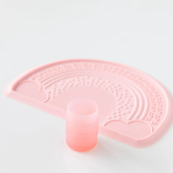 Bumkins Silicone Starter Cup: Pink sits in front of a pink silicone placemat on a white background.