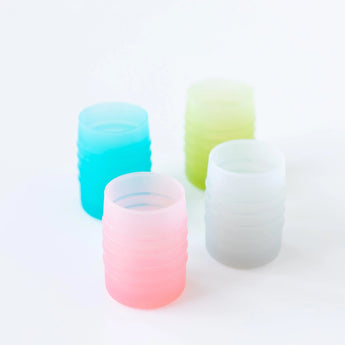 Four cups, including Bumkins Silicone Starter Cup: Pink, sit on a white background.