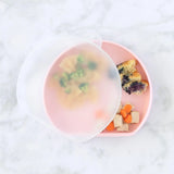 Bumkins pink divided plate with pasta, broccoli, bread & fruit, topped with CPSIA compliant translucent Silicone Stretch Lid.