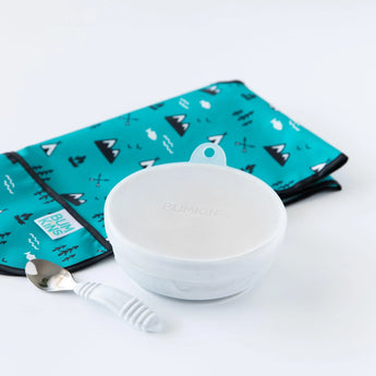 Bumkins Silicone Stretch Lid for Grip Bowl on a gray bowl next to a gray spoon and a folded teal bib on a white background.
