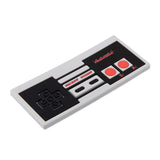 Bumkins NES™ Controller Teether: Retro-style with black D-pad, two red buttons, and gray Select and Start for baby gum relief.