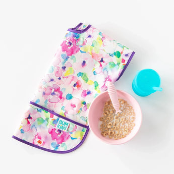 Bumkins Junior Bib in Watercolor, pink bowl with cereal and milk, teal cup on white background.