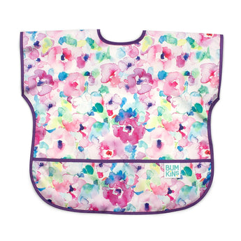 Bumkins Junior Bib: Watercolor features colorful floral patterns, purple trim, a front pocket, and waterproof fabric for easy cleaning.