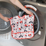 Someone is putting a Bumkins Junior Bib: Minnie Mouse Classic, with an easy-wipe stain-resistant design, into the washing machine.