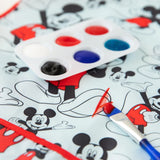 Close-up of a paintbrush with red paint on a Bumkins Short-Sleeved Smock: Mickey Mouse Classic, next to a paint palette.