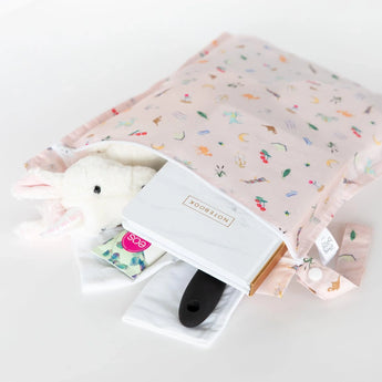 Bumkins Wet Bag: Princess Magic holds a stuffed unicorn, notebook, brush, and more on a white background.