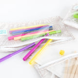 Close-up of Bumkins Clear Travel Bag 3-Pack: Wander on a white background, filled with colorful markers and art supplies.